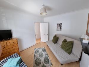 een woonkamer met een bank en een tv bij Roomy dog friendly Gosport town house sleeps 6 in Gosport