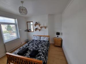 戈斯波特Mayfield , 2 bed slp 6 Roomy dog friendly Gosport town house的卧室里有一张床，床铺是黑白相间的棉被