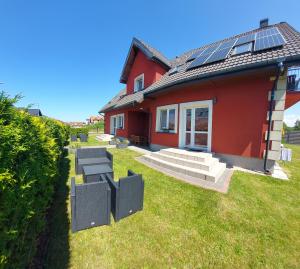ロビにあるJaskółka 2の屋根に太陽光パネルを敷いた赤い家