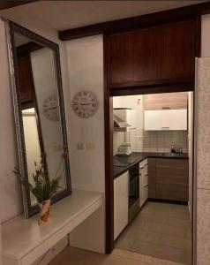 a kitchen with a mirror and a clock on the wall at COSY APARTMENT FILIP IN THE HISTORICAL OLD TOWN in Koper