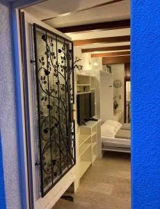 a room with a glass door with a television and a bedroom at COSY APARTMENT FILIP IN THE HISTORICAL OLD TOWN in Koper