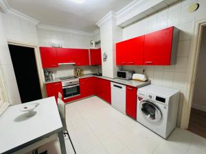 uma cozinha com armários vermelhos e uma máquina de lavar roupa em Sancho el Sabio em San Sebastián