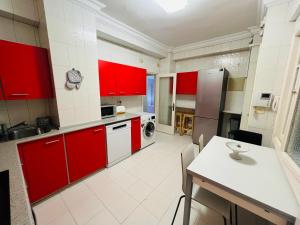 uma cozinha com armários vermelhos e uma mesa em Sancho el Sabio em San Sebastián