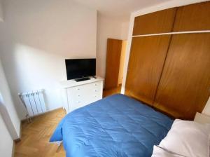 a bedroom with a blue bed and a television at Live & Work Apart in Buenos Aires city, near park! in Buenos Aires