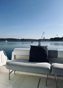 a white couch sitting on a dock next to the water at Dream Night Boats in Poreč