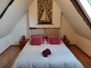 a bedroom with a large bed with pink pillows at Gîte Les 3 Voiles in Ploumilliau