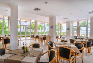 a dining room with tables and chairs and windows at Royal Marina Beach in Chernomorets