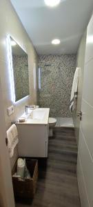 a bathroom with a sink and a toilet and a mirror at Apartamento en playa de Laxe in Laxe