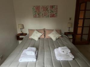 ein Schlafzimmer mit einem Bett mit Handtüchern darauf in der Unterkunft La casita de LOS CERROS DE SMA in San Martín de los Andes + 38 Fotos