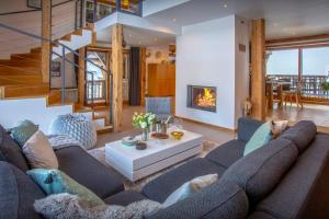 a living room with a large couch and a fireplace at Chalet Pativerdan - OVO Network in Samoëns