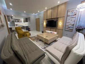 Jeddah Luxury stay for Self Check-In Apartment في جدة: غرفة معيشة مع كرسيين وطاولة قهوة