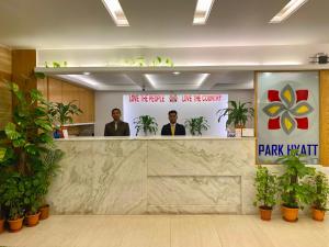 two men standing behind a counter in a lobby at Park Hyatt Dhaka in Dhaka