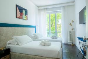 2 letti bianchi in una camera con finestra di LEOPOLDA HOME a Firenze