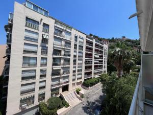 um edifício de apartamentos com bancos em frente em Studio terrasse et parking privé em Nice