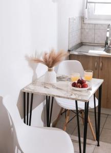 een tafel met een fruitschaal en twee stoelen bij Dreamy Delight Studio in Heraklion