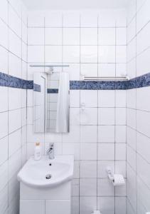 a white bathroom with a sink and a mirror at Dreamy Delight Studio in Heraklio