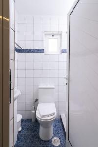 een witte badkamer met een toilet en een raam bij Dreamy Delight Studio in Heraklion