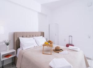 a white bedroom with a bed with a table on it at Dreamy Delight Studio in Heraklio