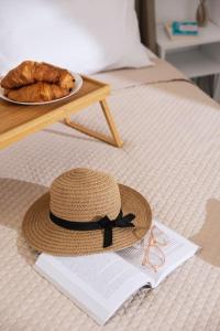 a hat and a plate of bread on a bed at Dreamy Delight Studio in Heraklio