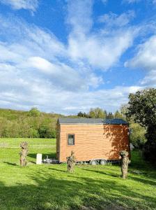 a small wooden cabin in a field with a sky at Joy Tiny House Perche in Madeleine