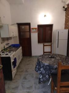 a kitchen with a stove and a table in it at Departamento Zona Centro Ubicado A 1 Cuadra De La Terminal De Ómnibus con Cochera Techada in San Fernando del Valle de Catamarca