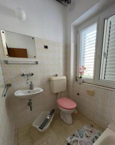 La salle de bains est pourvue de toilettes et d'un lavabo. dans l'établissement Apartmani Zorka, à Podstrana