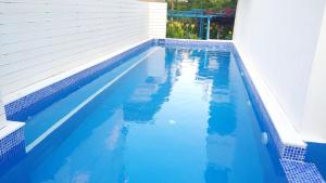 ein Pool mit blauem Wasser und ein Gebäude in der Unterkunft Ibiscus and Lily Apartments in Rhodos (Stadt)