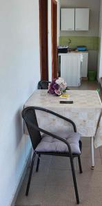 - une table avec une chaise et une table avec des fleurs dans l'établissement Apartmani Zorka, à Podstrana