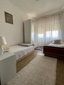 - une chambre avec 2 lits et une grande fenêtre dans l'établissement Apartmani Zorka, à Podstrana