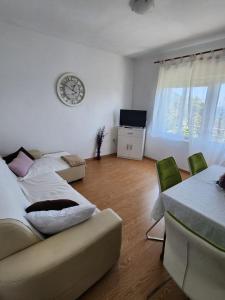 - un salon avec deux canapés et une horloge murale dans l'établissement Apartmani Zorka, à Podstrana