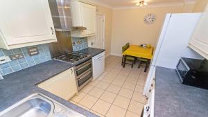 eine Küche mit Spüle und Herd oberen Backofen in der Unterkunft Oyster Cottage Braunton | Sleeps 6 | Dog Friendly in Braunton