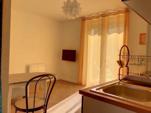 uma cozinha com um lavatório, uma mesa e cadeiras em Résidence Appartements Niort wifi-parking em Niort