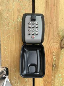 un téléphone portable est fixé à une porte en bois dans l'établissement T2 maison entre calme & ville, à La Riche