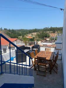 balcón con mesa y sillas de madera en Amiais River Beach House, en Amiães de Baixo