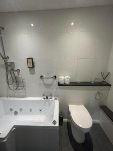 La salle de bains est pourvue d'une baignoire blanche et de toilettes. dans l'établissement The Highwayman Hotel, à Oxford