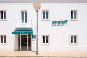 a street light in front of a white building at Praia FLH Hotels Ericeira in Ericeira