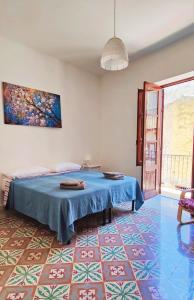 Schlafzimmer mit blauem Bett und blauem Boden in der Unterkunft Gurgiolo New Apartment in Trabia