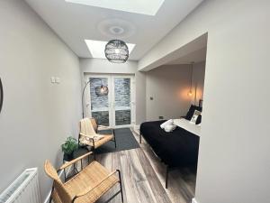 a bedroom with a bed and chairs in a room at Modern spacious Belfast city stay free parking in Belfast