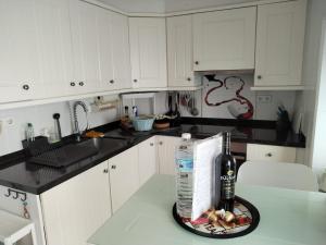 a kitchen with white cabinets and a bottle of alcohol at Small village house with beautiful sea views in Torrox