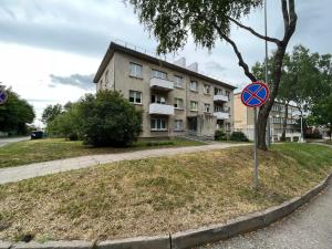 un cartello stradale di fronte a un edificio di Luxuria Modern Apartments - Self Check-in a Šiauliai