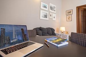 un computer portatile seduto su un tavolo con un libro di APARTMENTS BLITZ - Regarda Travel a Lazise