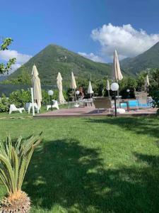 un parque con sillas y sombrillas y una piscina en Villa Lucia, en Castellammare di Stabia