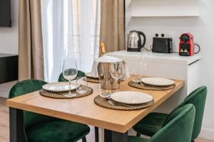 einen Holztisch mit Tellern und Weingläsern darauf in der Unterkunft Villa Hélianthe, 2mn à pied Monaco, Luxe - AS in Beausoleil