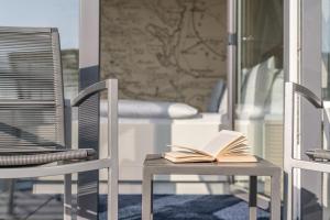 ein offenes Buch auf einem Tisch mit zwei Stühlen in der Unterkunft Küstenperle Strandhotel & Spa in Büsum