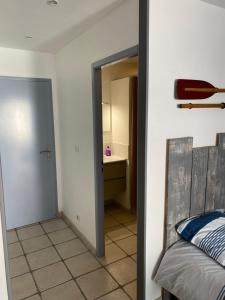 1 dormitorio con 1 cama y puerta que conduce a un baño en Chambre indépendante dans une villa, en Saint-Trojan-les-Bains