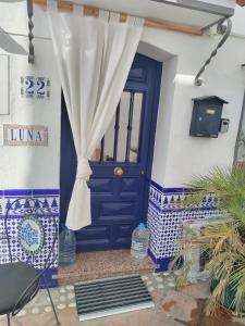 a blue door with a curtain on a house at Small village house with beautiful sea views in Torrox
