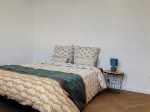 ein Schlafzimmer mit einem Bett mit einer Decke und Kissen in der Unterkunft Résidence Appartements Niort wifi-parking in Niort