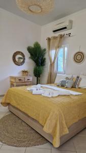 Aventora Apartments في ليغيا: غرفة نوم بسرير كبير مع بطانية صفراء
