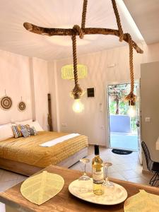 Aventora Apartments في ليغيا: غرفة نوم مع سرير وطاولة مع كؤوس للنبيذ