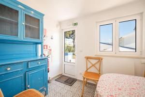 una camera con armadio blu e tavolo e sedie di GuestReady - A special place near the beaches a Colares